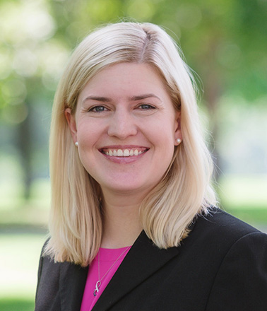 Portrait of Ashely Smith - woman with blonde hair wearing a blazer smiling at the camera