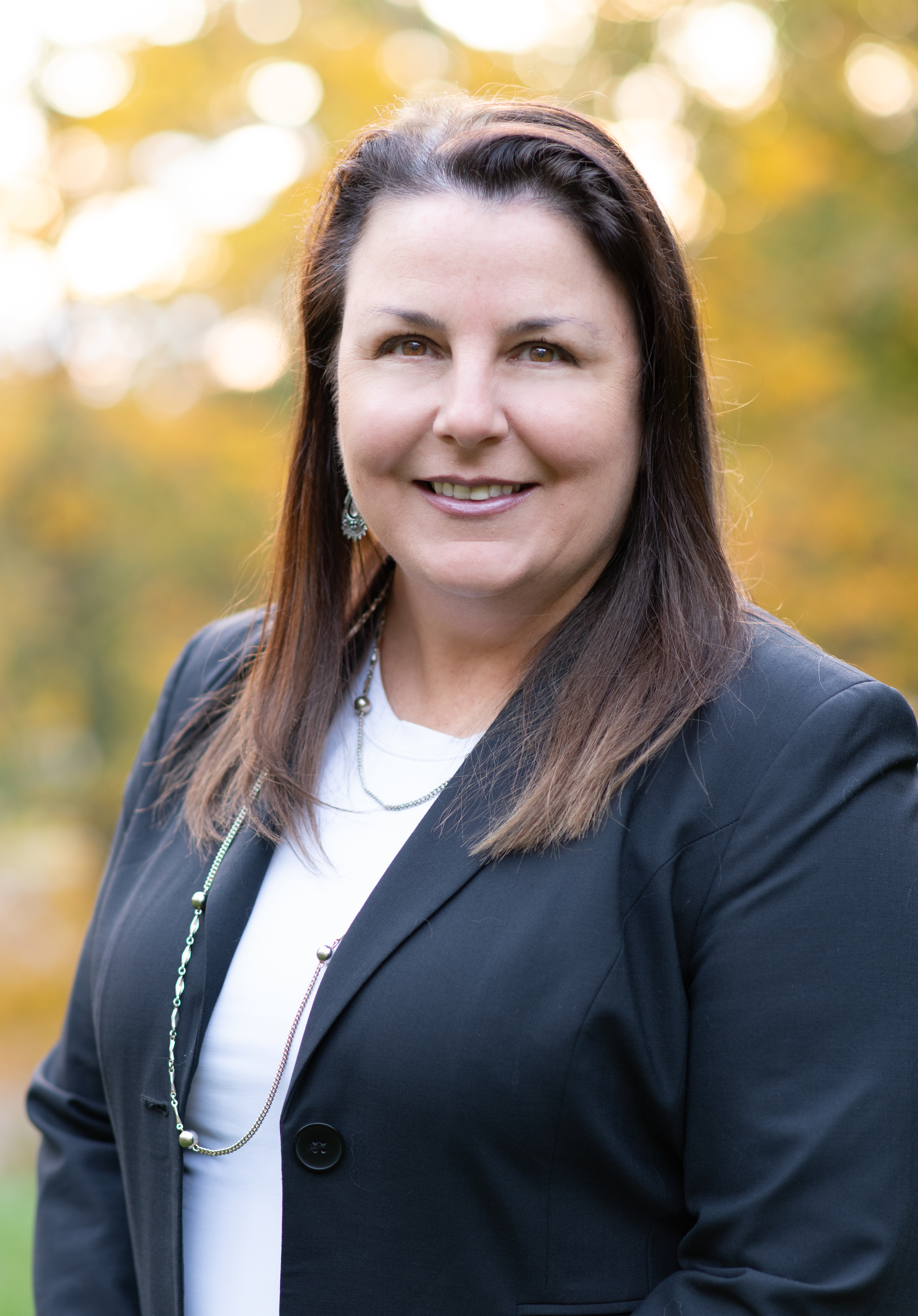 Portrait of Danielle Spicer. Brunette woman in a jacket smiling at camera.