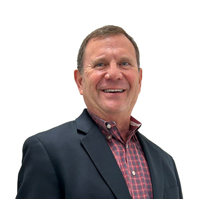 Portrait of Lawrence Goldberg - man in suit and plaid shirt smiling at camera