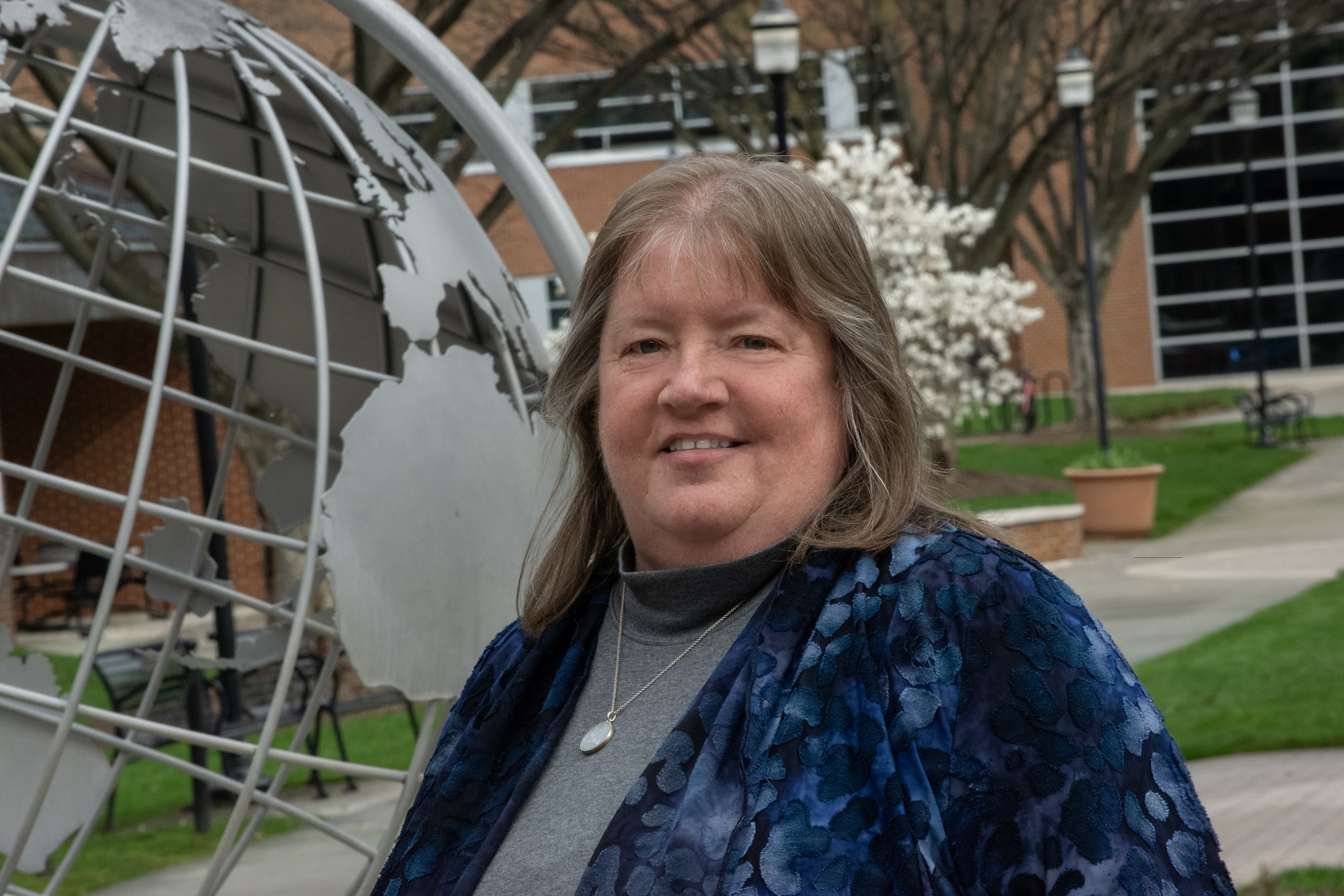 Photo of Shirley Clark. Woman wearing blue floral jacket smiling at camera.