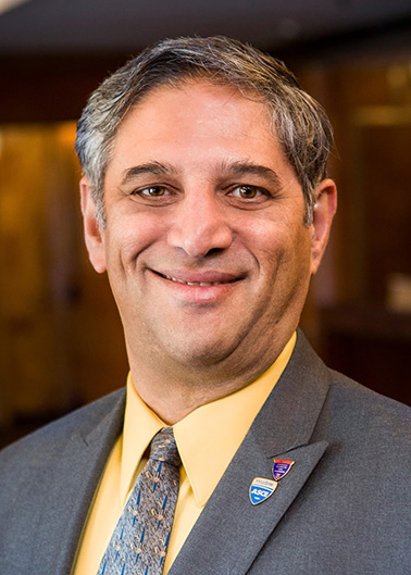 Portrait of Ziad Mazboudi - a man wearing a gray suit smiling at the camera