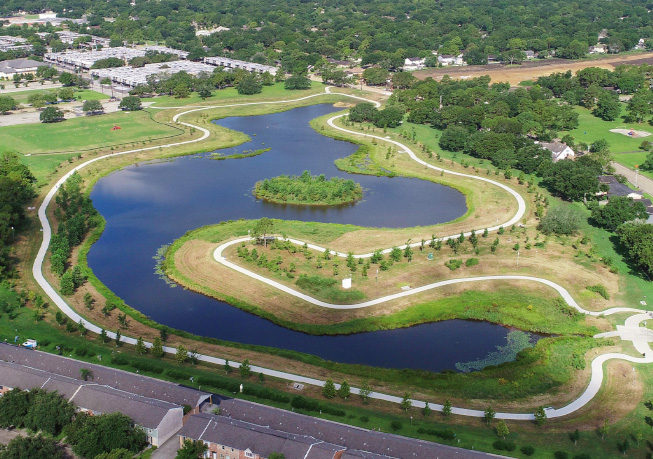 Aerial view of the Exploration Green detention basin, showing winding water channels, walking paths, and surrounding green space.