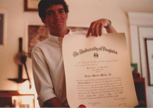 Portrait of Roger Millar holding his diploma
