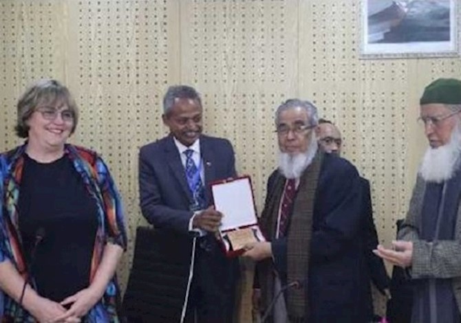 Section leaders presented crest to President Maria and Governor Kamal. Pictured are 4 people smiling in a room. 