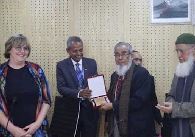 Section leaders presented crest to President Maria and Governor Kamal. Pictured are 4 people smiling in a room. 