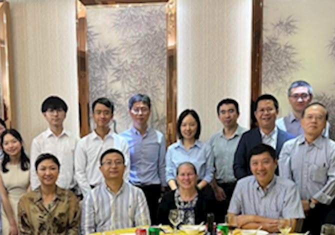 Greater China Section welcome dinner. Pictured are 20 people behind a table smiling at the camera. 