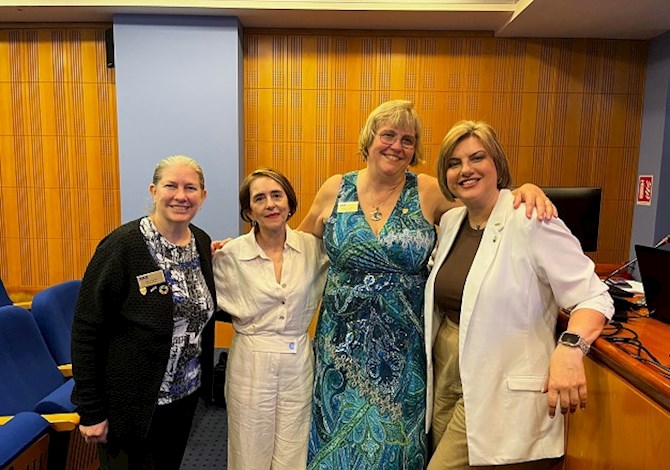 Pictured: Four people smiling looking at the camera.