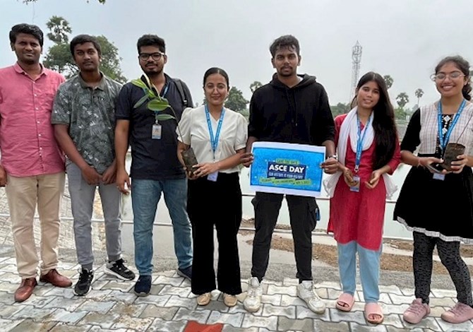 7 people facing the camera smiling. 1 person is holding an ASCE Day sign.