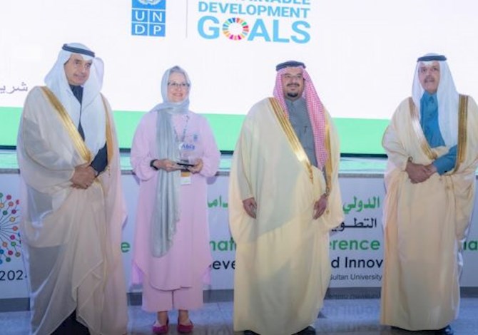 Four people facing the camera and smiling.