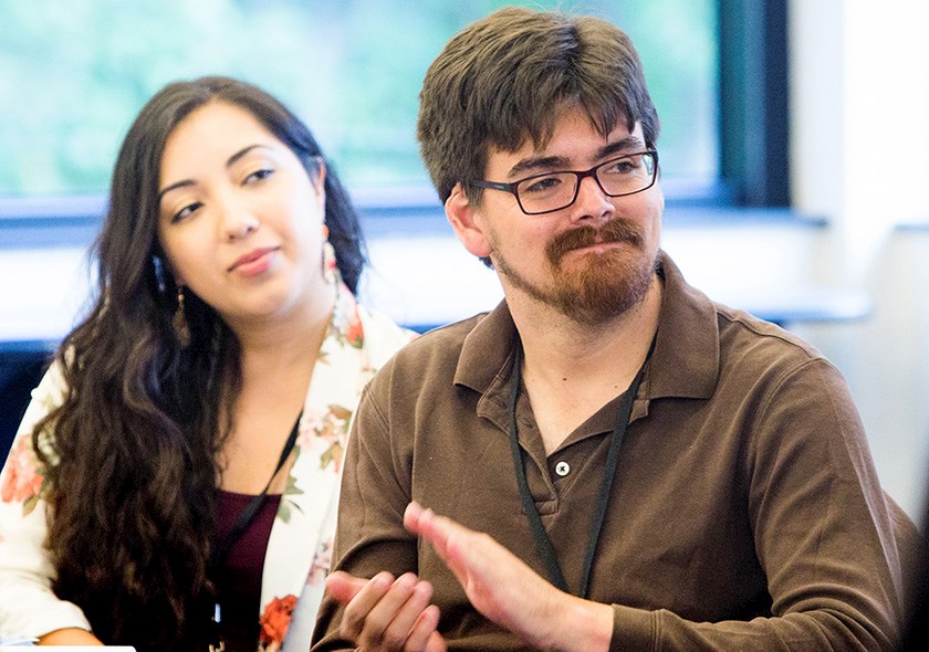 Two people listening to speaker