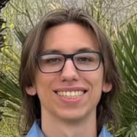  A man with glasses is wearing a light blue polo shirt. 