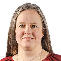 Woman in red blouse smiles at the camera.