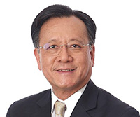 man in suit with glasses smiling at camera