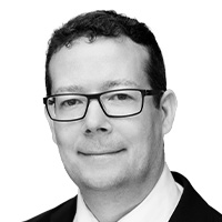 Man in suit and tie smiles at the camera