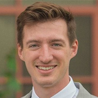 Man in gray jacket and white shirt.