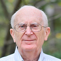 Man in glasses and striped shirt smiles at the camera.