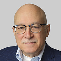 Man wearing glasses looks at the camera. 