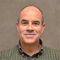 Man smiles at camera.