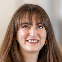 Woman with brown hair smiles at the camera.
