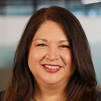 Woman with brown hair smiles at the camera. 