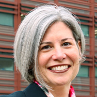 Woman with short blonde hair smiles at the camera.