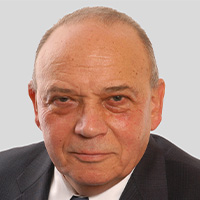 Man wearing a suit and tie looks at the camera. 
