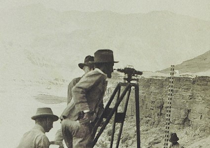 old photo of three men surveying the land