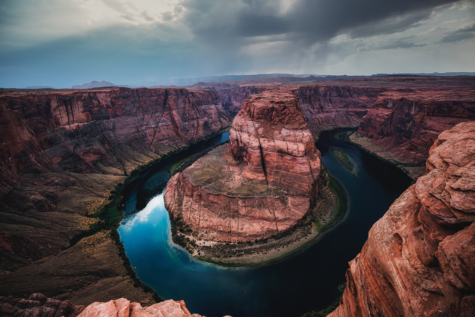 large rock formations with a circular water-filled canyon carved into it