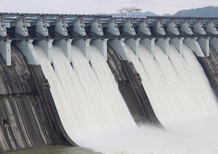 water flowing through gates of a dam at full volume