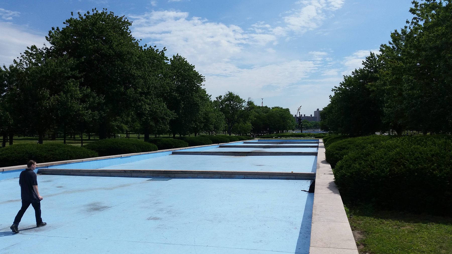 man walking in empty fountain