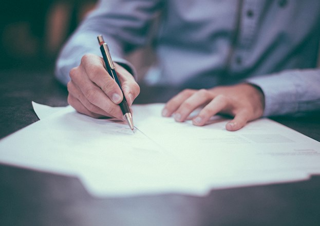 man writing on paper