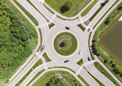 circular road with cars on it and green space in the middle
