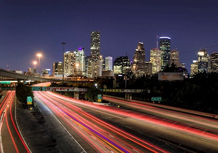 light trails on a highway leading to a skyline
