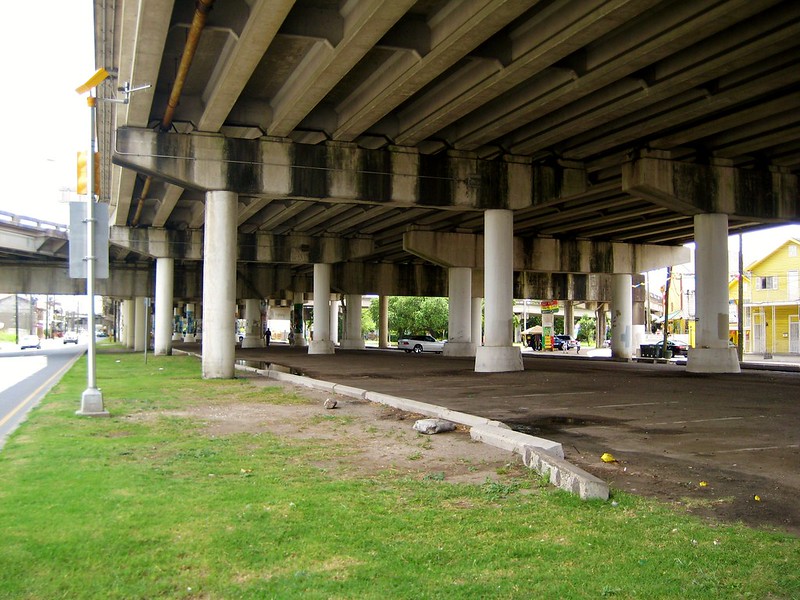 a large overpass overwhelms a road