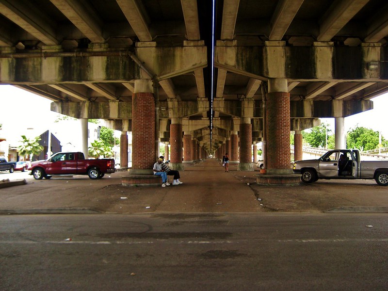 men sit under an underpass