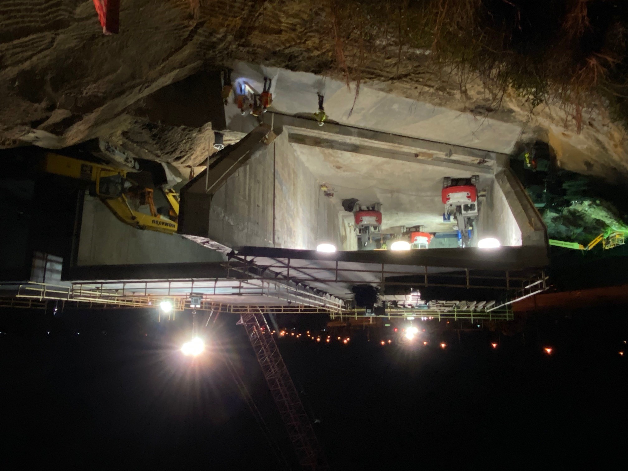 excavators remove dirt from a concrete box