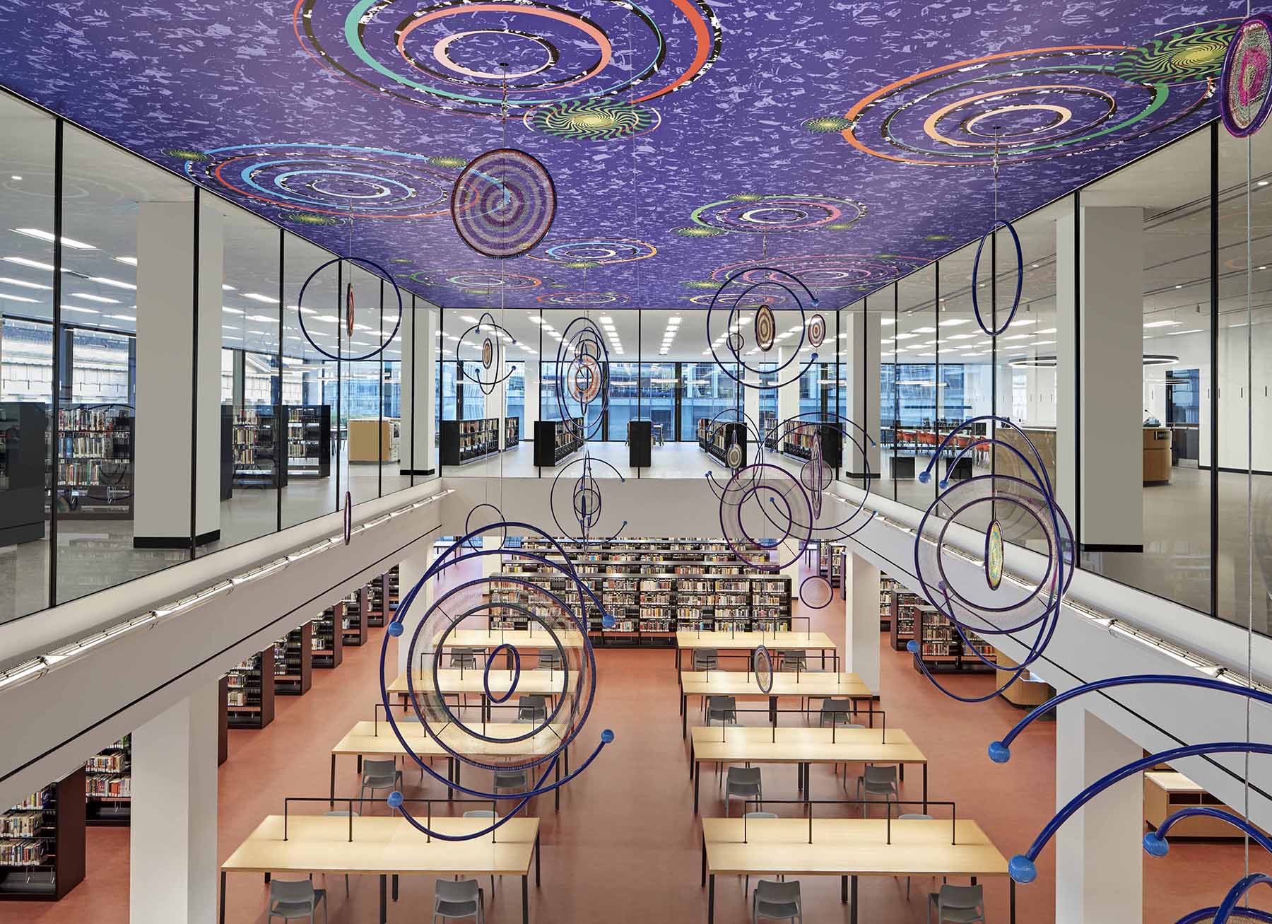interior photo of the two story great reading room with its desks and books and its multicolor ceiling with various designs