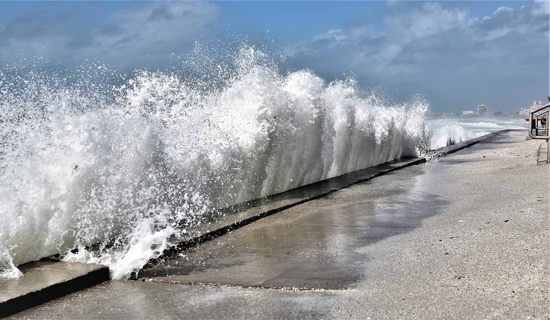 waves crashing at a flood wall at a beach