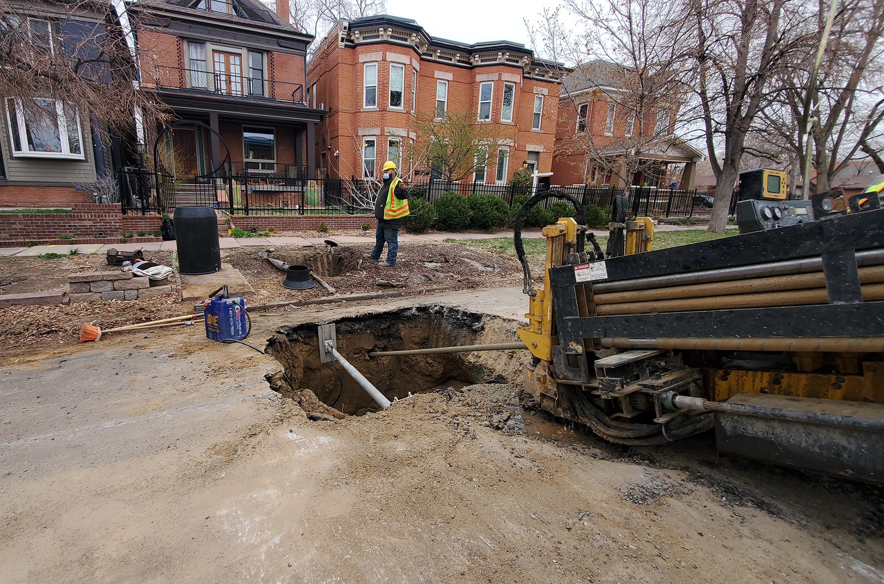 workers removing pipe from under a street