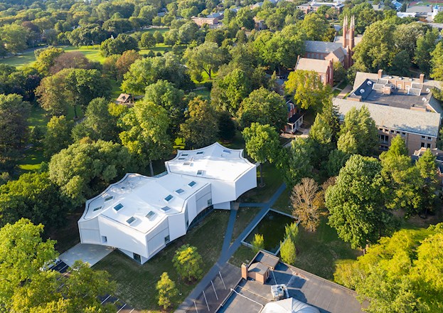 white, many sided building surrounded by trees and other buildings