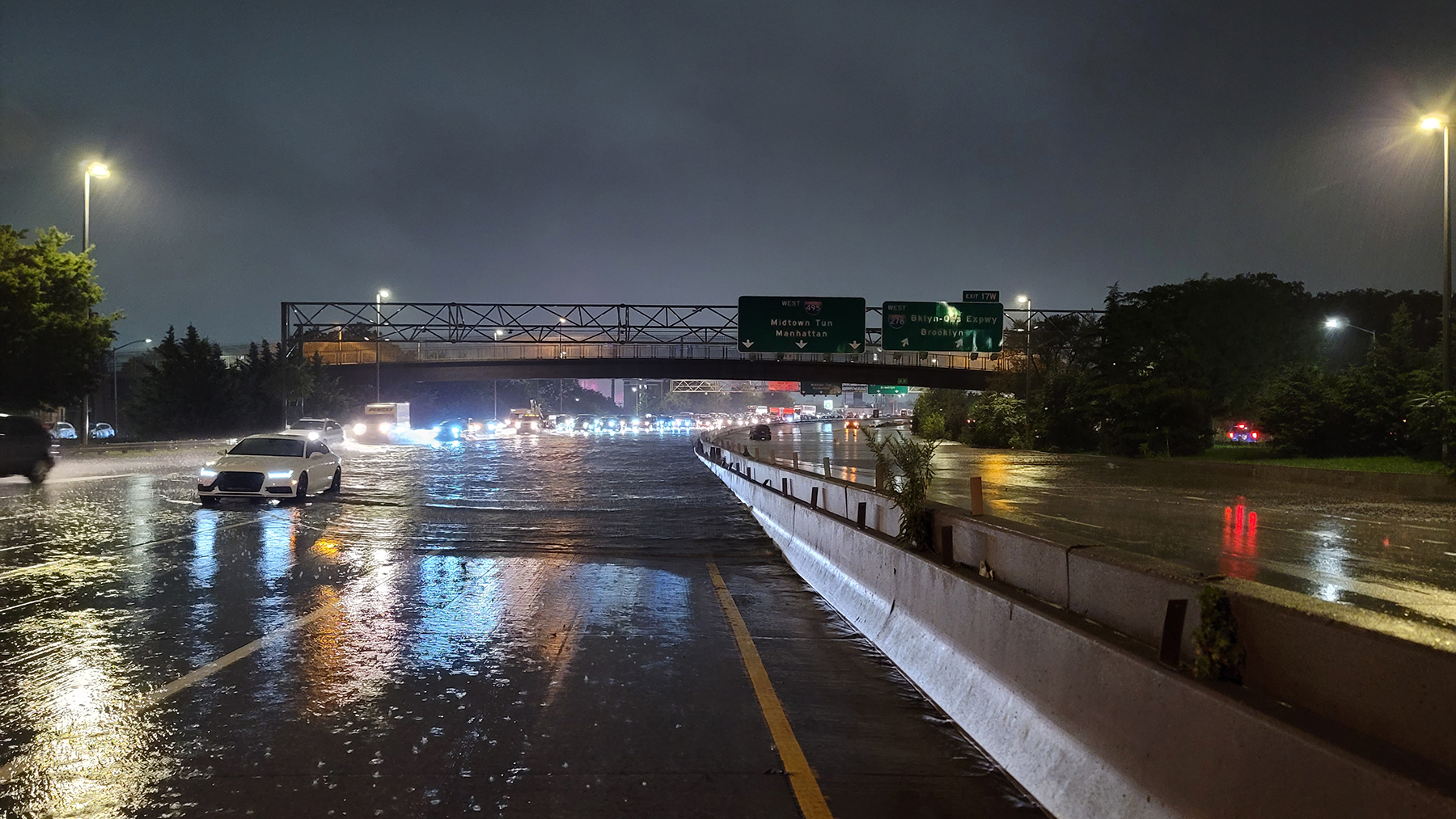 flooded highway with white care in standing water