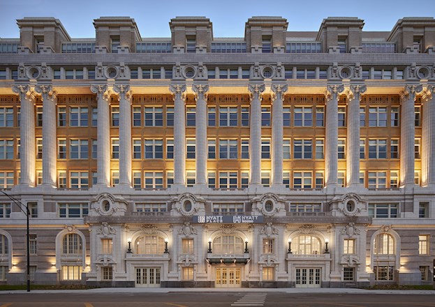 white and yellow multistory building with columns on the facade