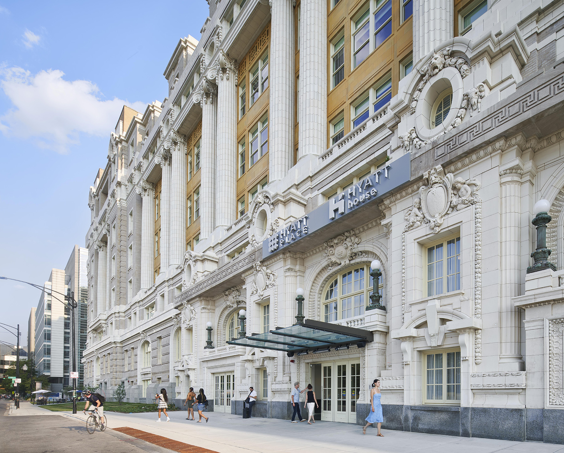 people walking in and out of building with a white facade