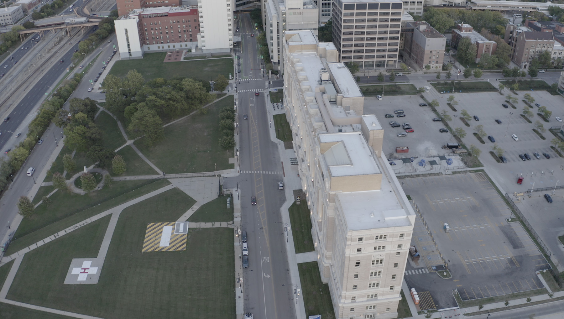 aerial view of façade and roof of a building. trees and other buildings are in the background.