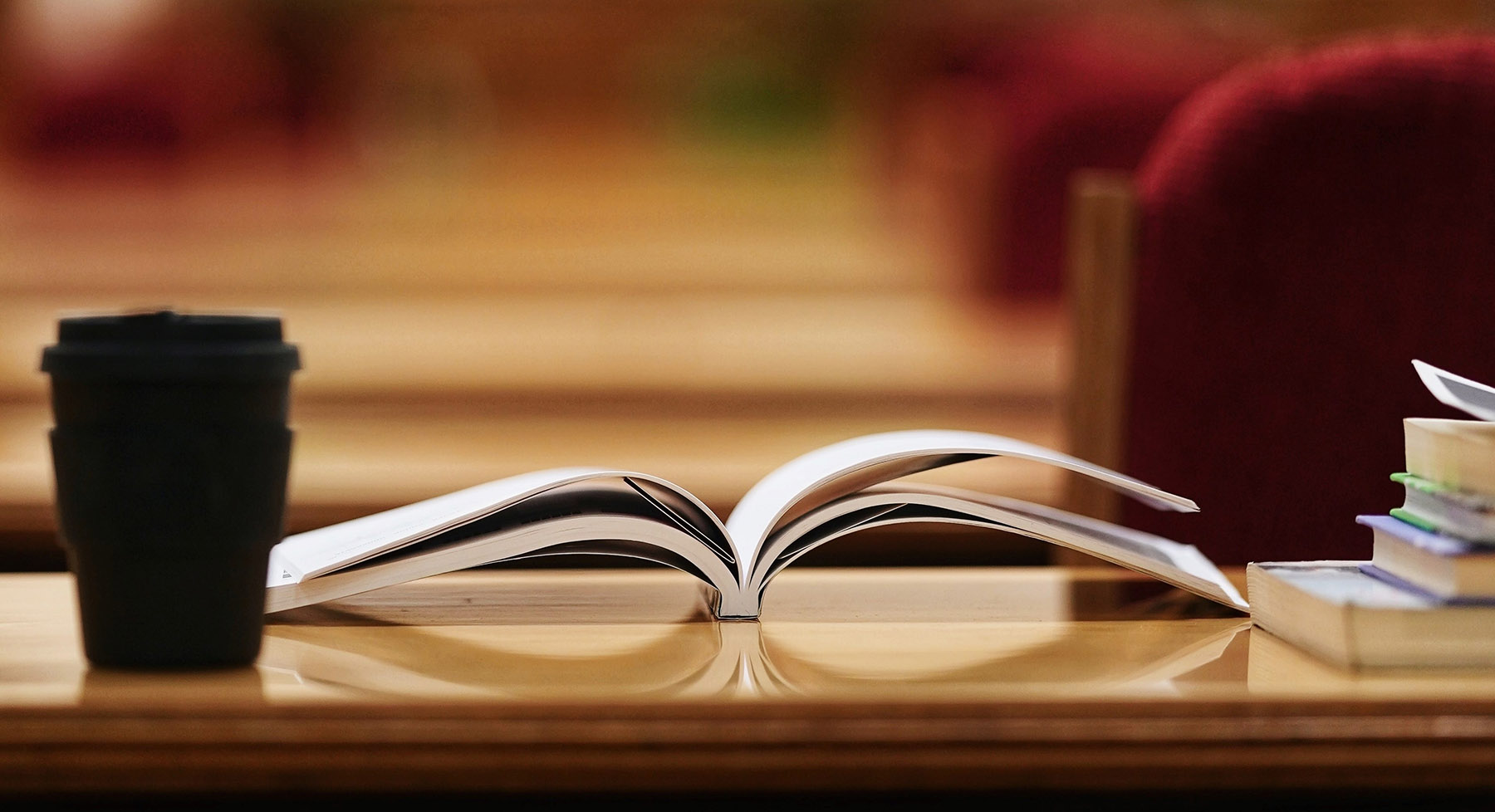 coffee mug on top of a table piled with books