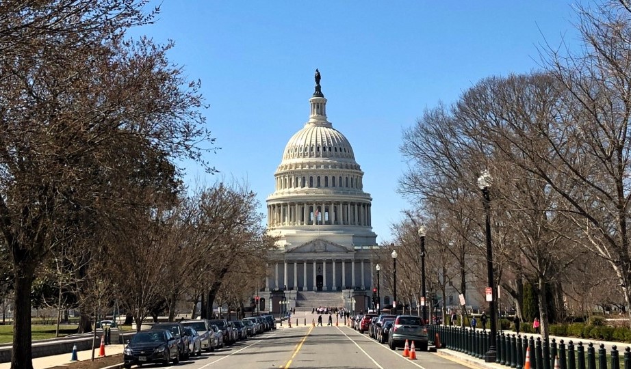 white marble building topped by a rotunda and gold point