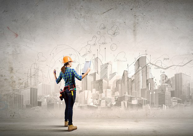 woman wearing hard hat, tool belt, boots and jeans and a shirt holding a notepad