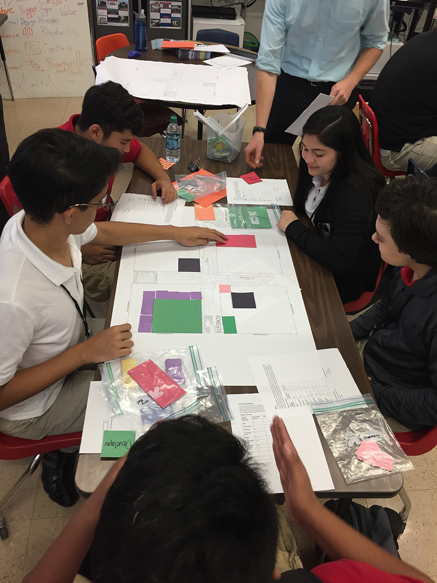 young students sitting at a table creating neighborhoods