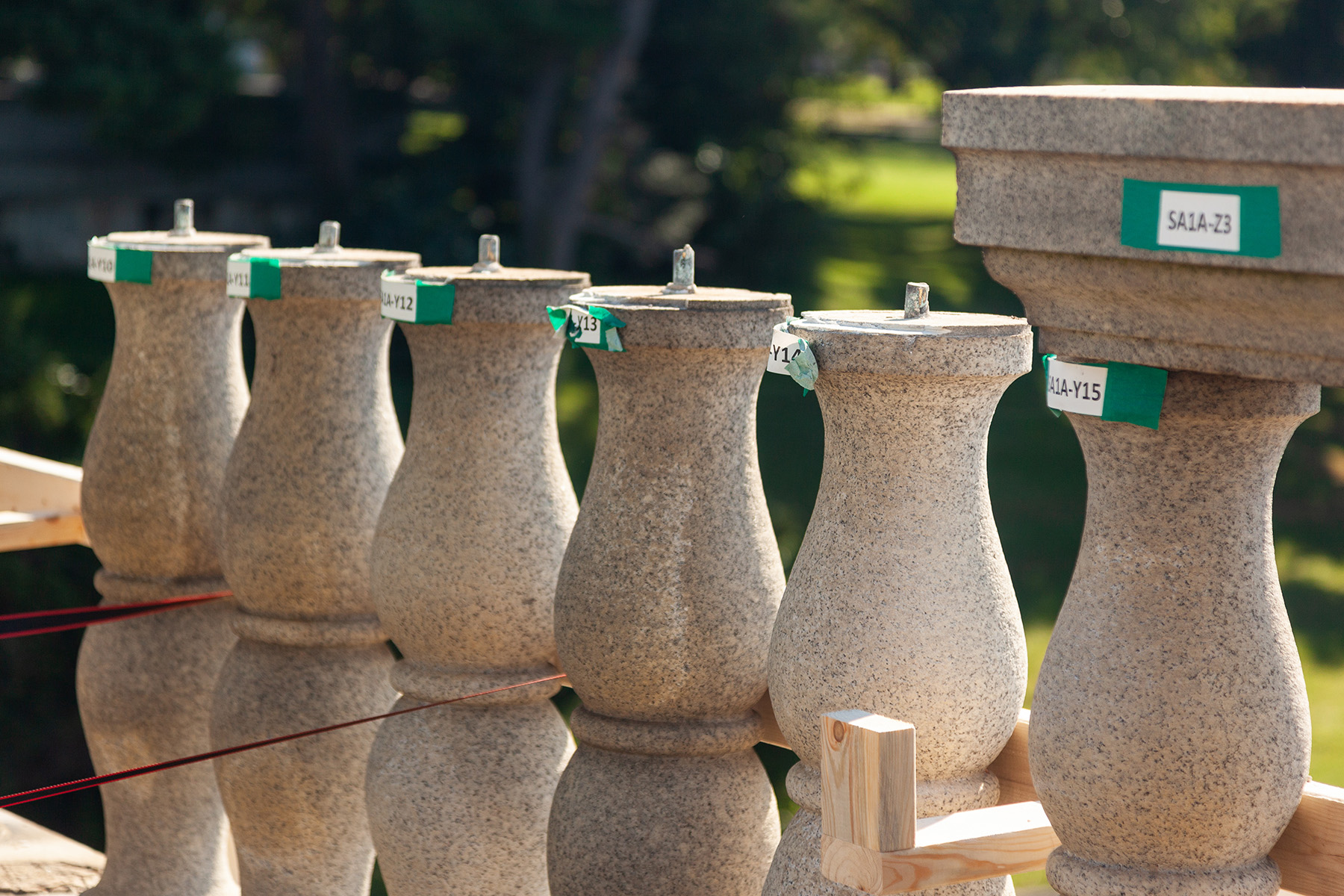 granite balustrades with small green and white tags on them