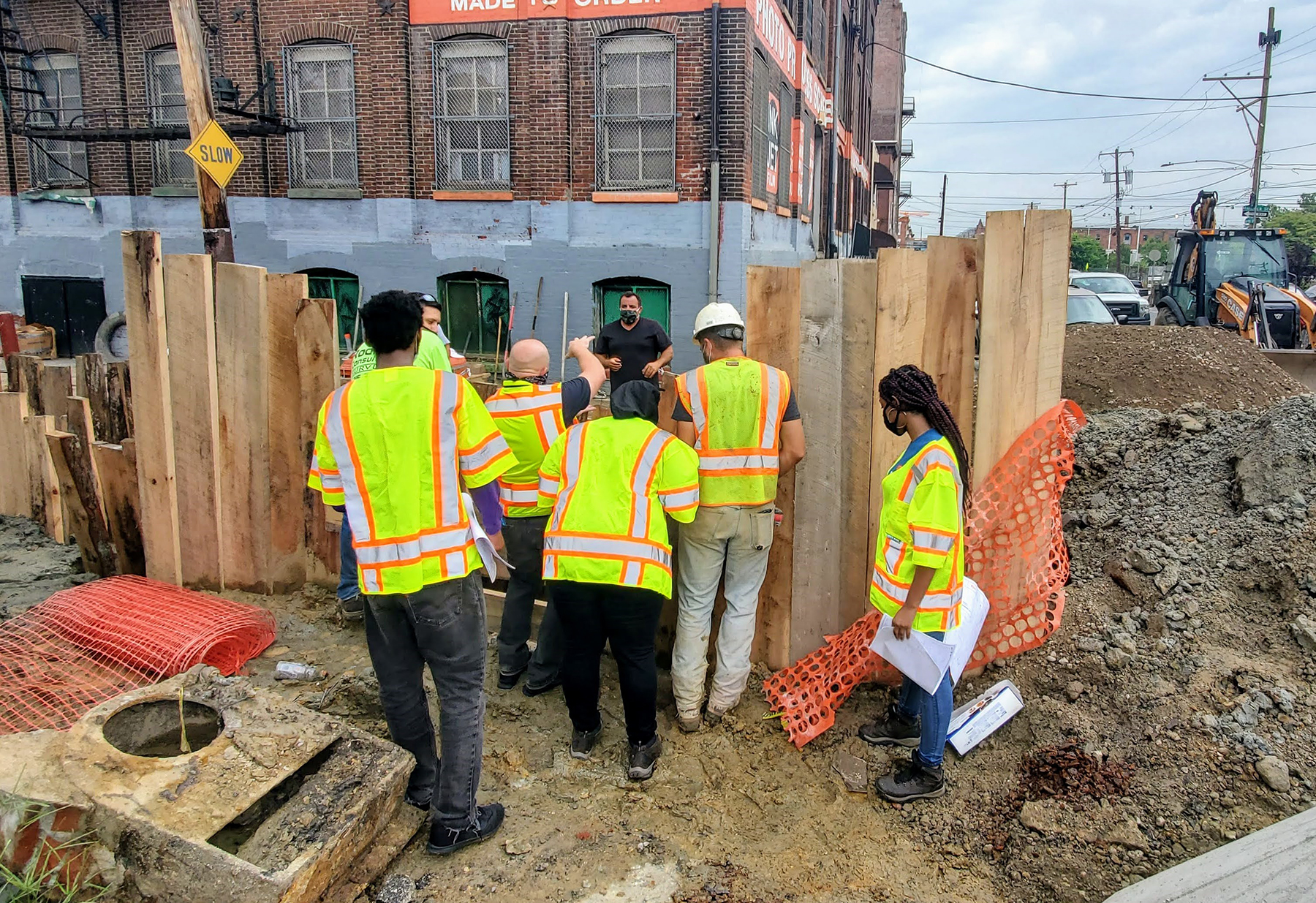 people in high visibility vests look at a construction site